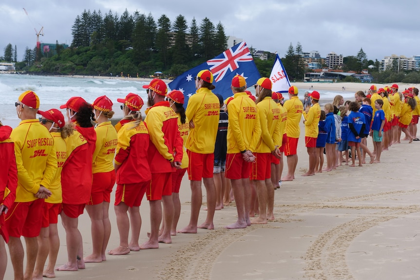 A row of lifesavers in red and yellow on the beach.