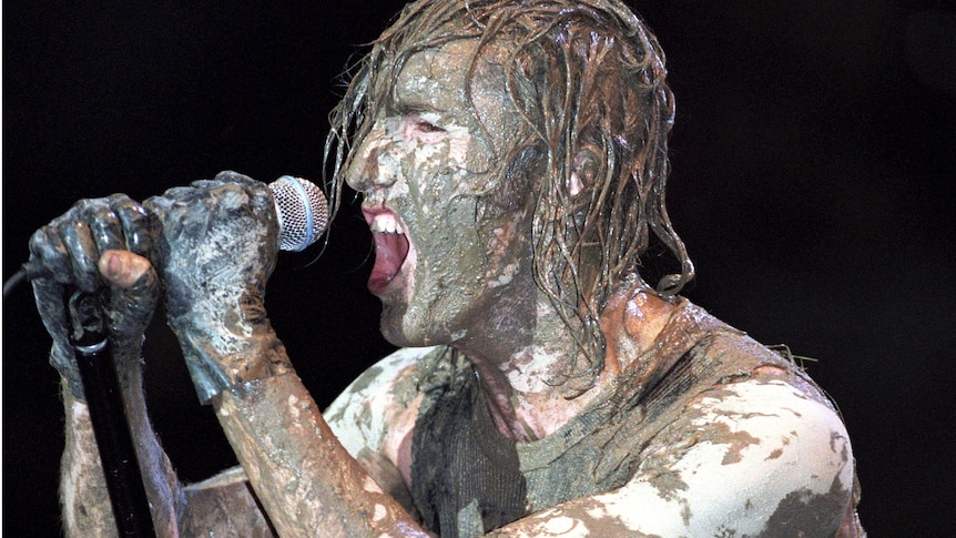 Nine Inch Nails' Trent Reznor caked in mud and performing live at Woodstock '94