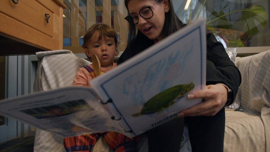 Eleni Early Years leader with a child reading a Turtleboy book