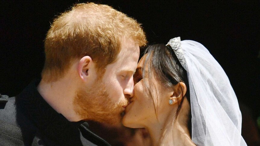 Prince Harry and Meghan Markle kiss.
