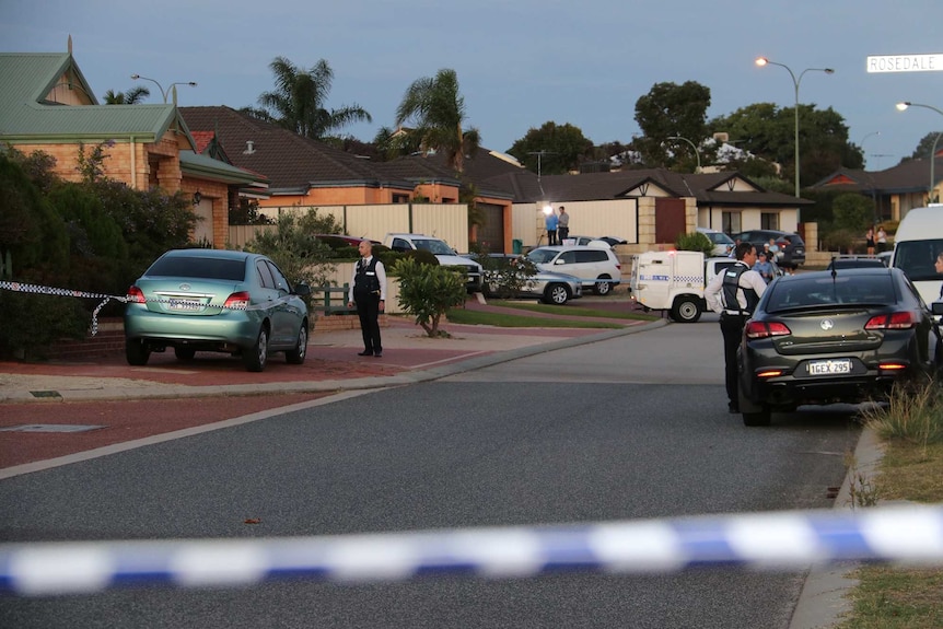 Police officers and cars outside a Perth house with police tape cordoning off the street.