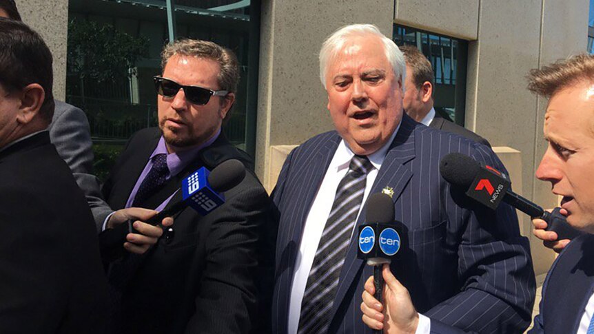 Clive Palmer and his minders outside the Federal Court in Brisbane