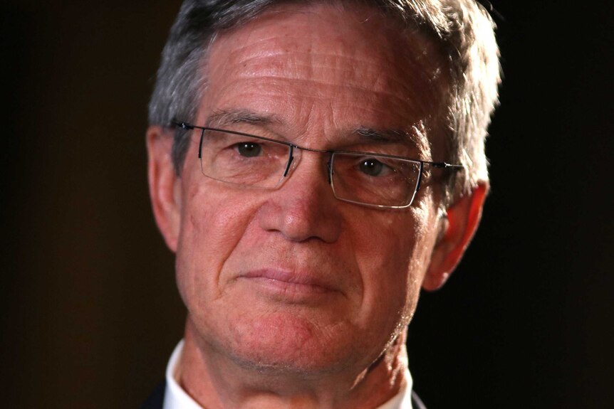 A headshot of Mike Nahan against a black background.