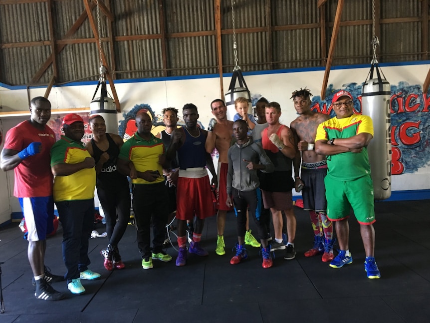 Cameroon boxers and local boxers from Warwick stand in front of punching bags