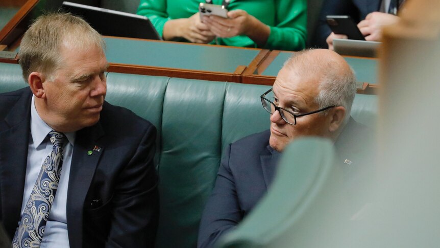 Morrison, partially obscured, sits in the House of Representatives chamber.