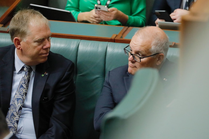 Morrison, partially obscured, sits in the House of Representatives chamber.