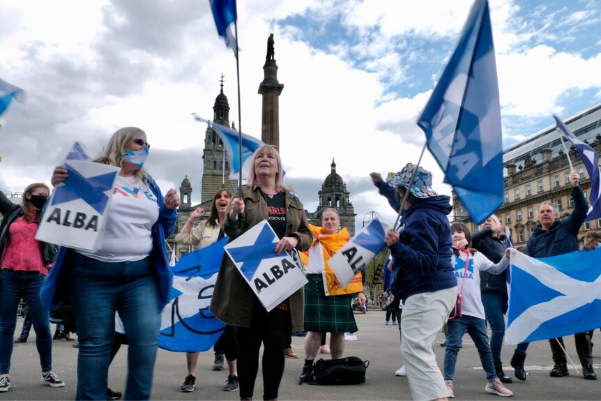 A group of women waving Scottish flags 