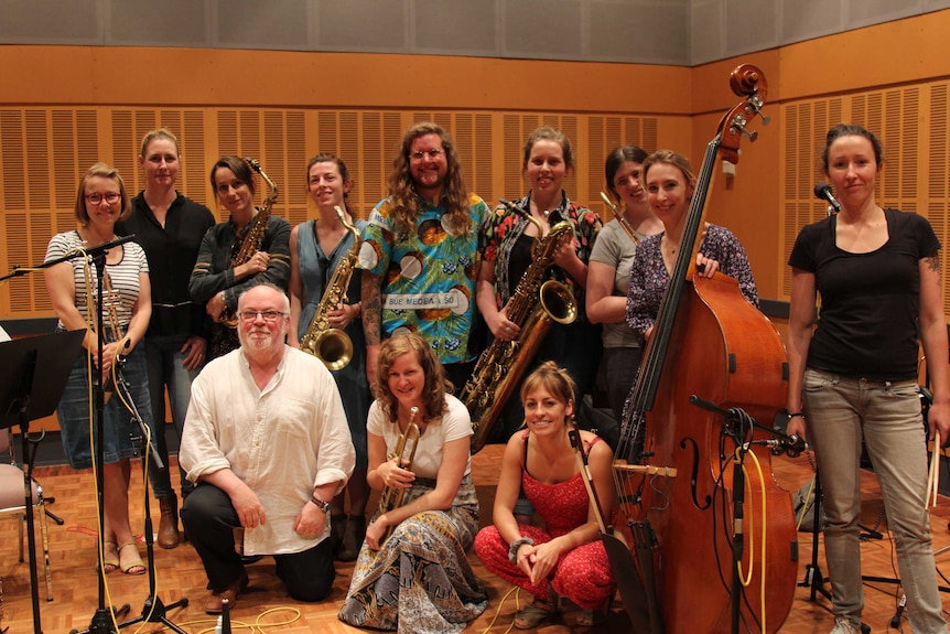 Host Andrew Ford with a group of jazz musicians holding instruments.