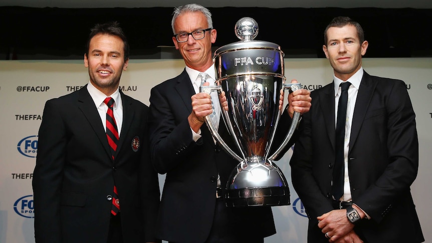 FFA chief David Gallop holds the FFA Cup trophy in February 2014.