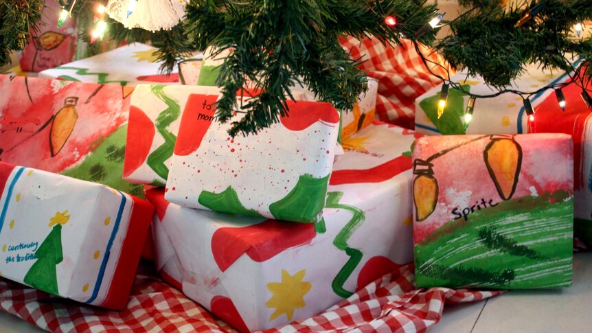 Homemade wrapping paper used on Christmas presents under a tree.