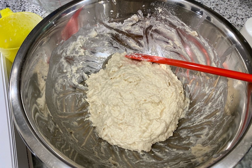 Bread dough ingredients stirred together in a mixing bowl, for Nigella's white sandwich loaf.