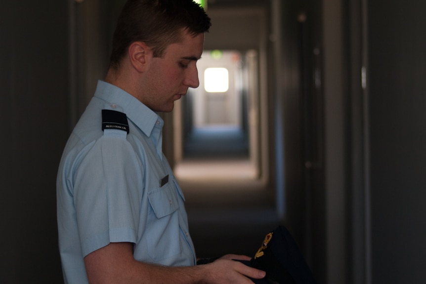 FLGOFF Shane Ivimey looking at hat his RAAF hat emblem at the Edinburgh RAAF Base near Adelaide.