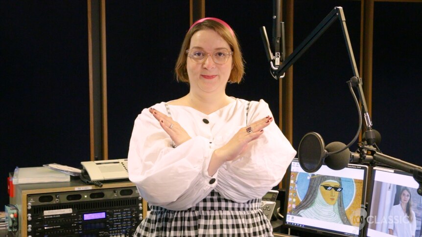 ABC Classic Vanessa Hughes in the ABC radio studio. She has her arms crossed in an "X" sign in front of her chest.
