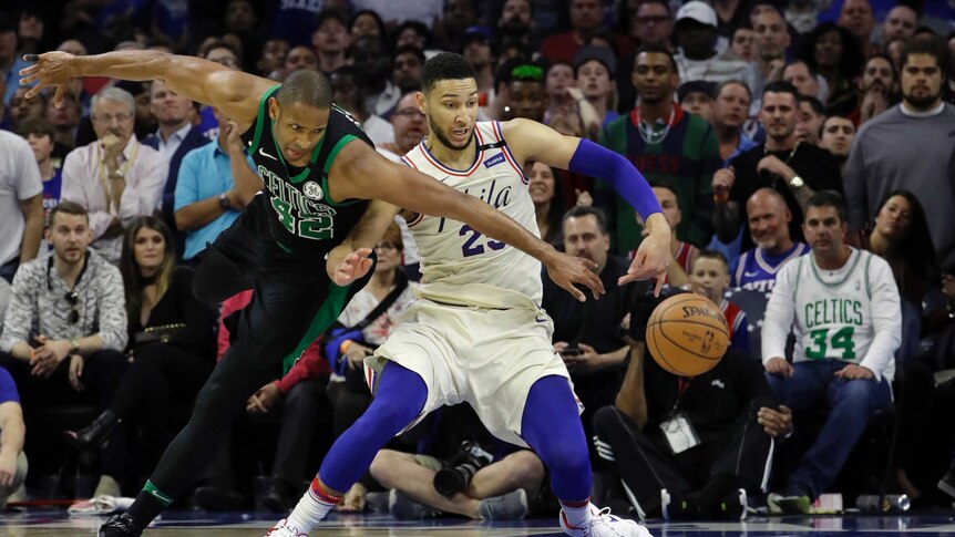 Ben Simmons struggles to get the basketball as Al Horford reaches around him.