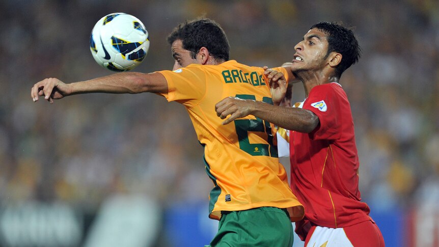 Australia's Alex Brosque (left) competes for the ball with Oman's Mohammed-Saleh-ali al-Musalami at Sydney's Olympic stadium.