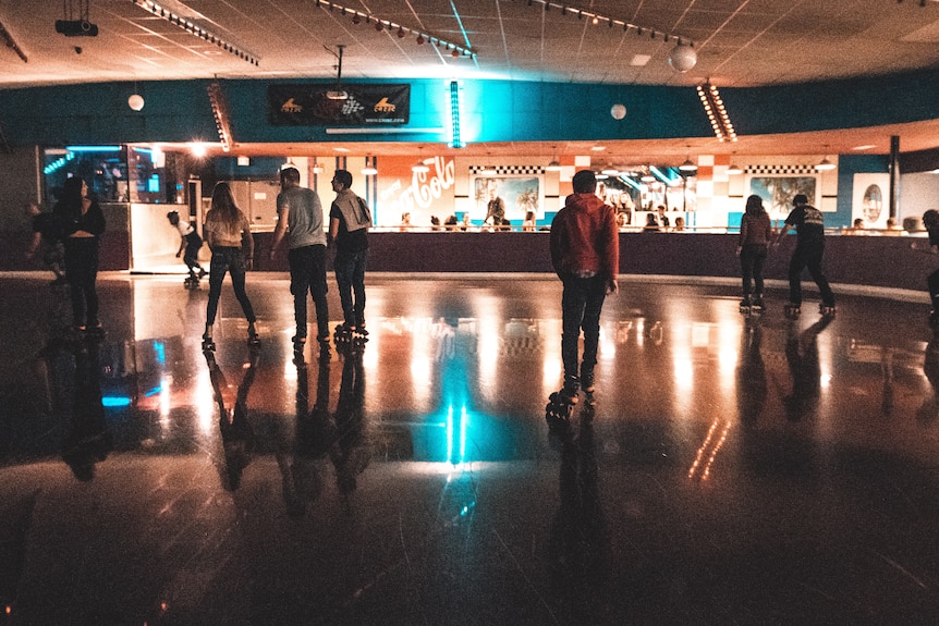 People with their skates on at a skating rink.