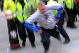A police officer knocks newspaper seller Ian Tomlinson to the ground