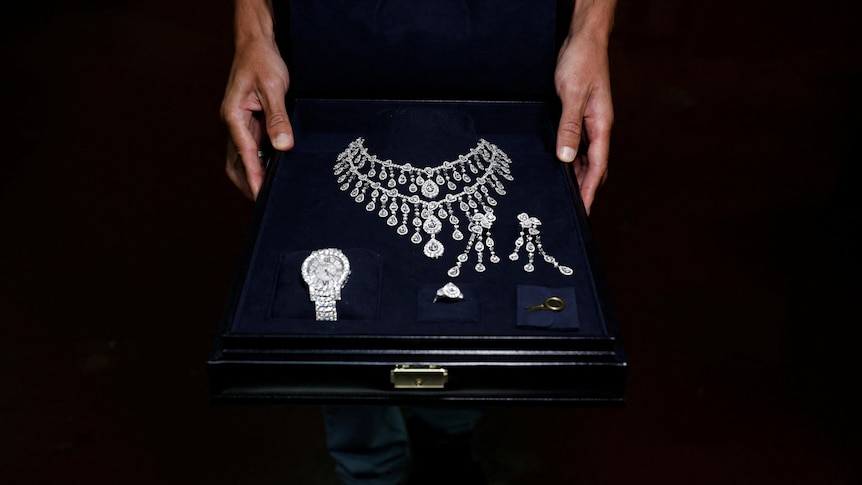 A black box containing a diamond necklace, earrings, watch and ring.