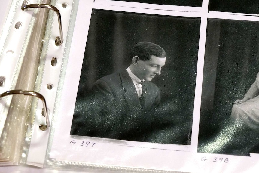 Black and white image of a man in a contact sheet inside a spiral binder.