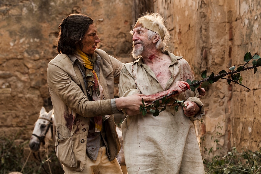 Colour still of Adam Driver holding onto Jonathan Pryce in 2018 film The Man Who Killed Don Quixote.