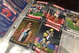 Pages of a plastic folder hold photos of AFL players from the Bulldogs, St Kilda and Fremantle.