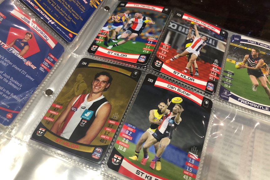 Pages of a plastic folder hold photos of AFL players from the Bulldogs, St Kilda and Fremantle.