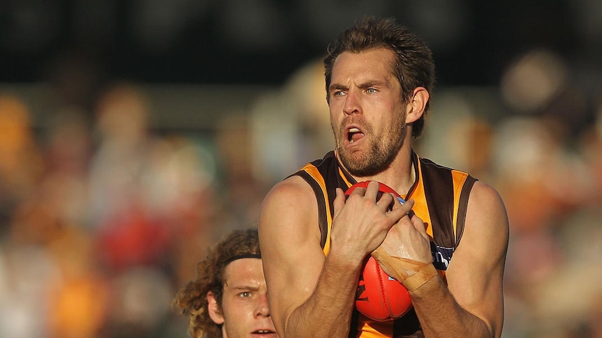 Luke Hodge of the Hawks marks in front of Jack Hutchins of the Suns.