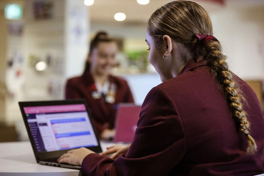 Two Year 12 students use laptops at John Paul College.