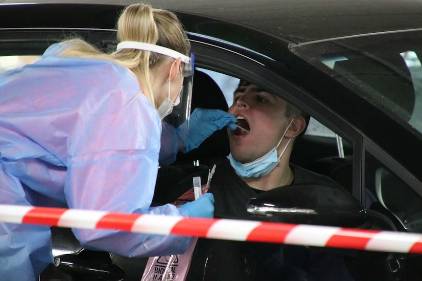 A person is tested for coronavirus at a drive-through site