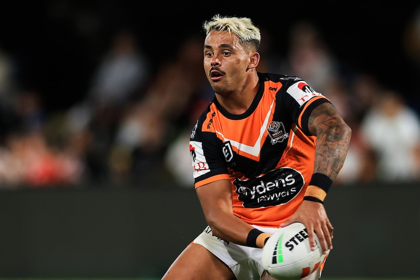 Wests Tigers' Jayden Sullivan shapes to pass a ball during an NRL preseason game.