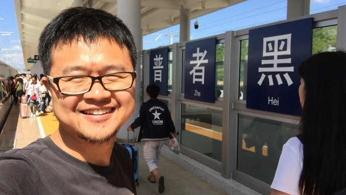 Chinese charity founder Lei Chuang, from the Yiyou Charity. He is standing at a train station.