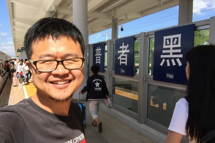 Chinese charity founder Lei Chuang, from the Yiyou Charity. He is standing at a train station.