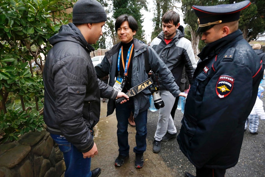 Russian police perform security checks on a photographer in Sochi.