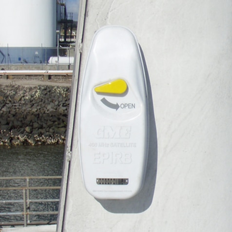 A float free EPIRB hanging on the wall of a boat.