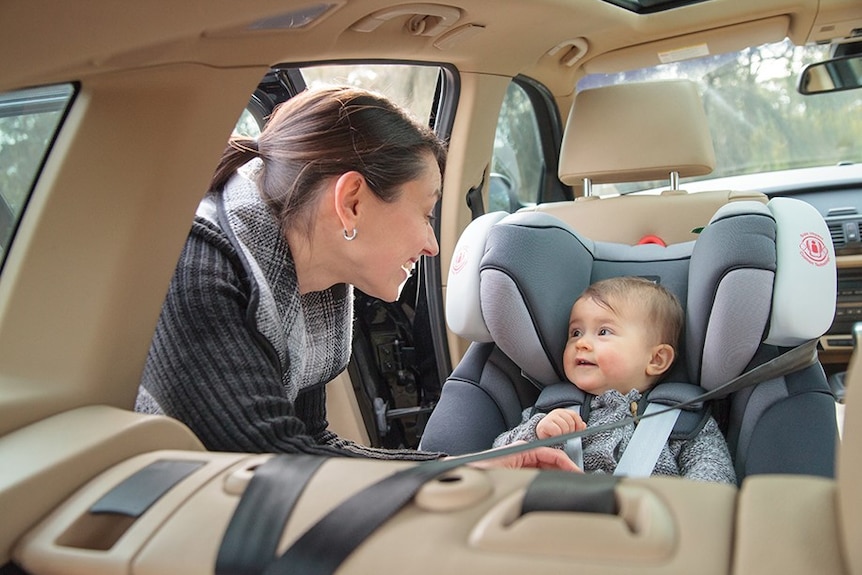 Woman putting baby in a car seat