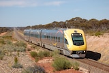 A yellow train on an outback railway track