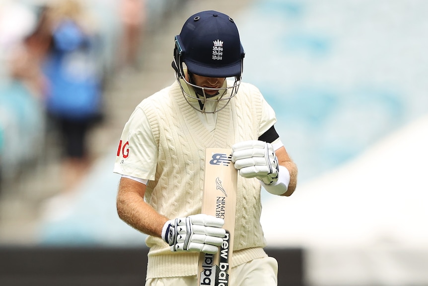 El bateador de Inglaterra Joe Root mira la parte inferior de su bate después de salir en la Prueba de Cenizas del Boxing Day contra Australia.