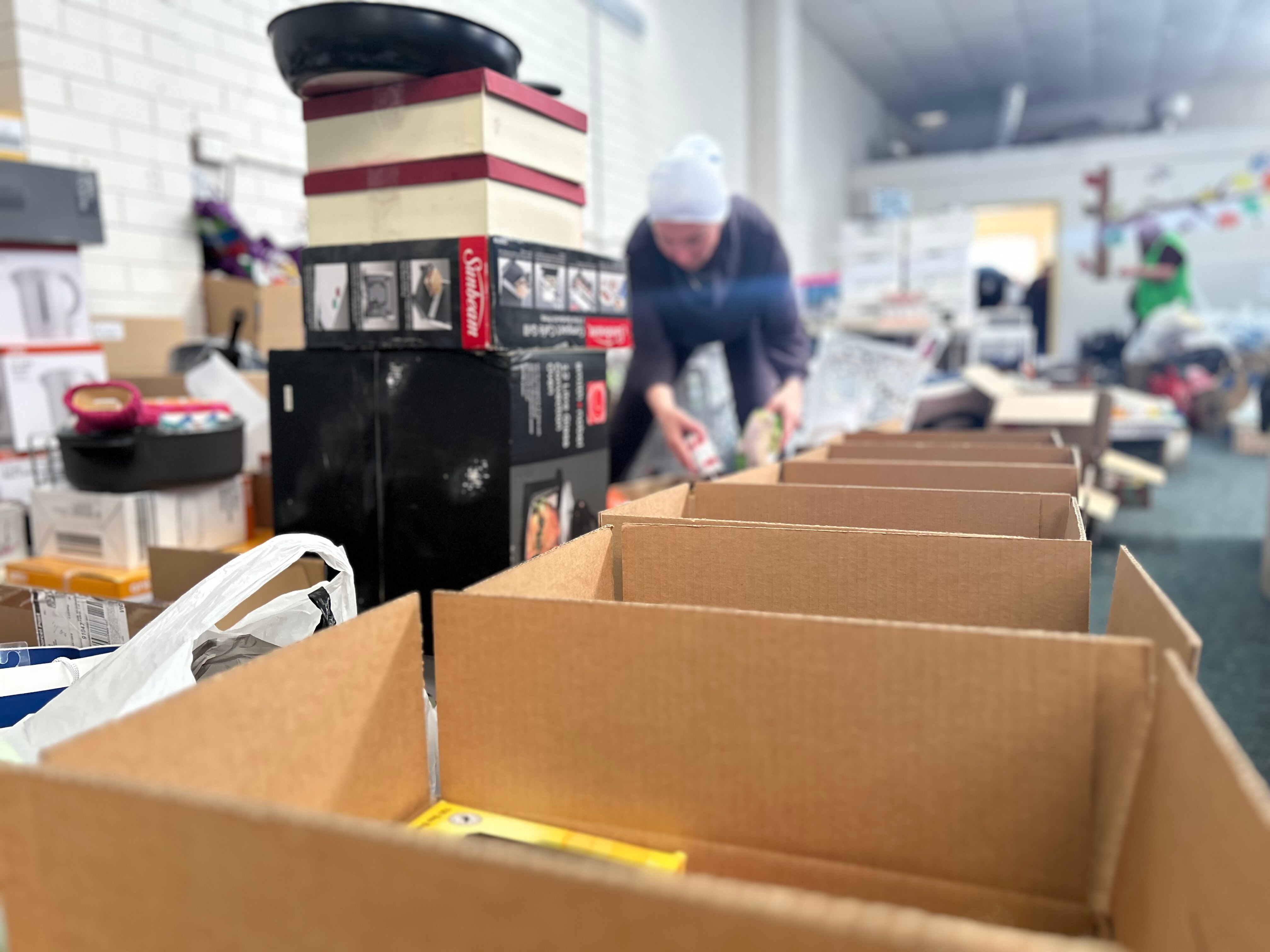 Lines of boxes are in view, being filled by a volunteer. 