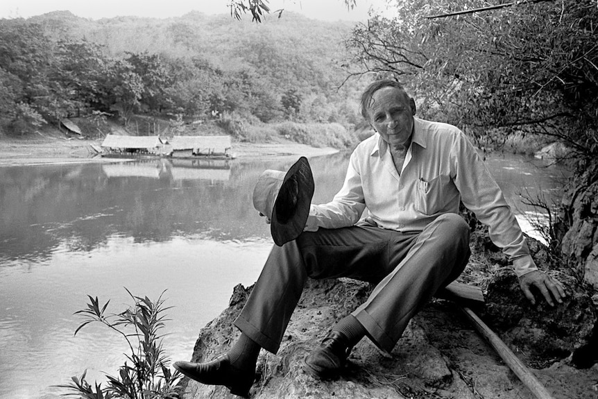 Weary Dunlop sits on the bank of the River Kwai.