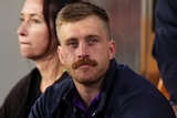 Cameron Munster sits on the sidelines of a Melbourne Storm NRL game after getting injured.