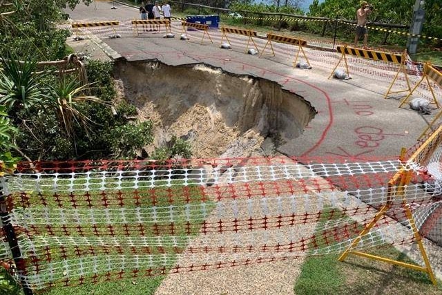 A road which has collapsed is cordoned off from the public