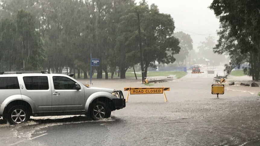 A town road flooding with vehicles trying to get throgh.