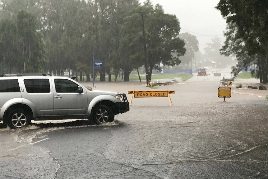 A town road flooding with vehicles trying to get throgh.