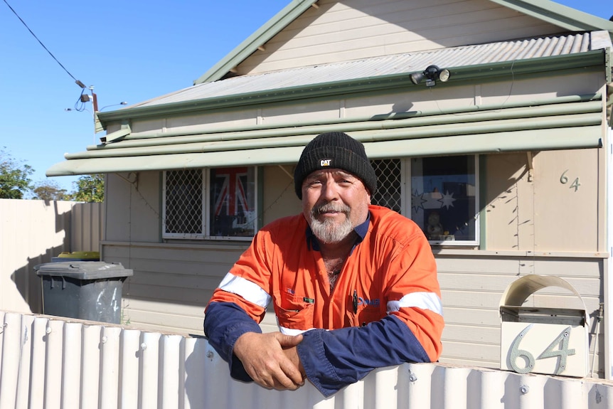 Kalgoorlie resident Tony Anderson wearing orange visibility shirt leaning on his front fence.