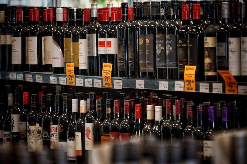 Bottles of wine on a shelf in a bottle shop.