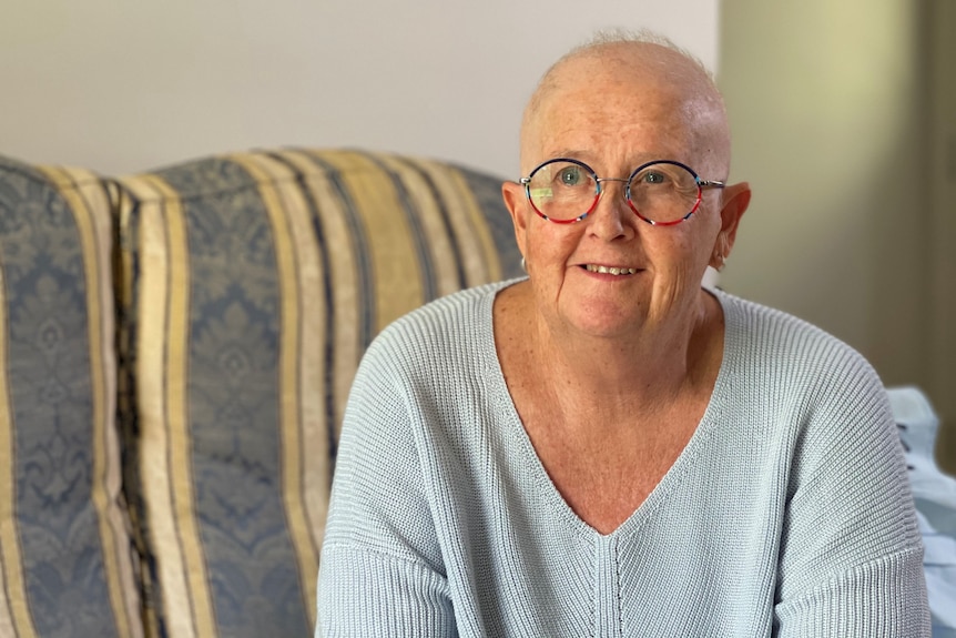 Therese McLean with bald head and wearing glasses