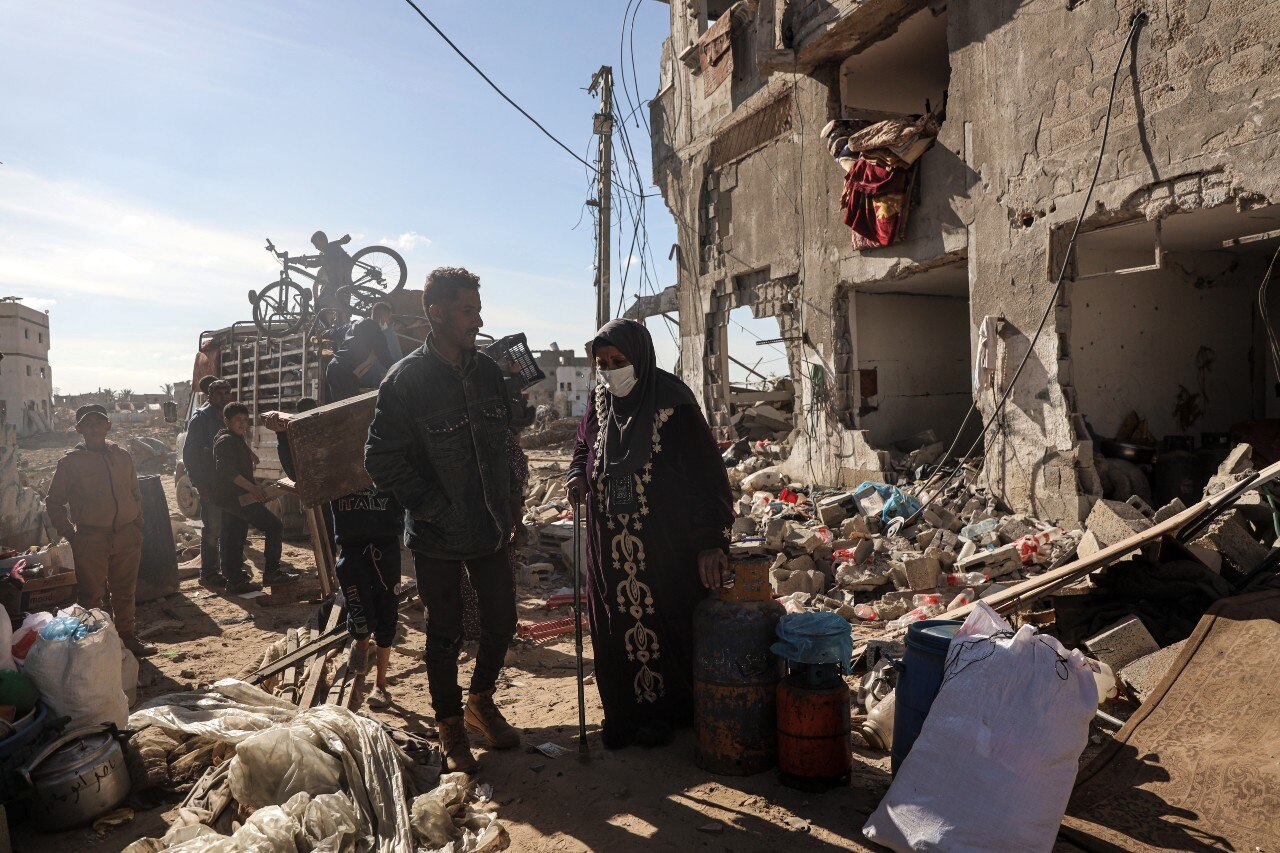 A man walking past several ruined buildings