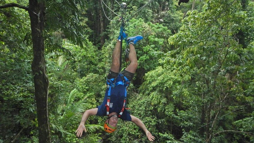 Man goes down zipline upside down hanging by feet in Cape Tribulation in Far North Queensland on February 10, 2019