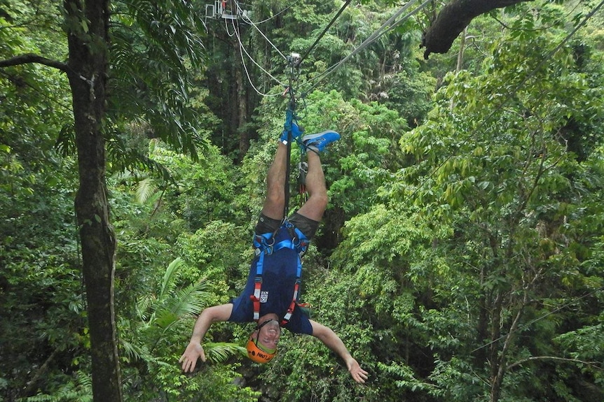 Man goes down zipline upside down hanging by feet in Cape Tribulation in Far North Queensland on February 10, 2019