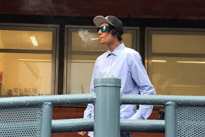 Joshua Leigh Jeffrey smokes a cigarette as he leaves the Burnie Magistrate's Court.